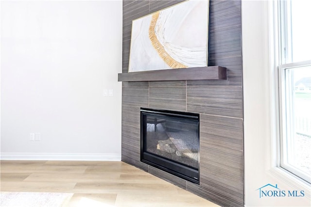 26328 Stillwater Dr, Perrysburg, OH 43551 - detailed view of a tile fireplace, baseboards, and wood finished floors