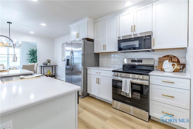 26328 Stillwater Dr, Perrysburg, OH 43551 - kitchen with appliances with stainless steel finishes, white cabinetry, light countertops, decorative backsplash, and light wood-style flooring