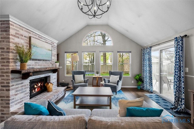 living room with a fireplace, vaulted ceiling, wood finished floors, and a chandelier