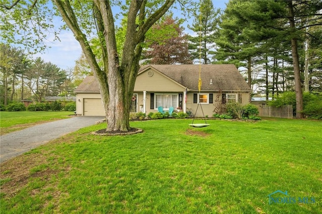 single story home with an attached garage, a front lawn, fence, and driveway