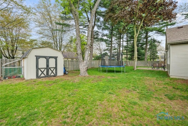 view of yard featuring a storage shed, a trampoline, and a fenced backyard