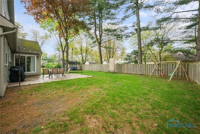 view of yard with a patio, a fenced backyard, a trampoline, and a playground