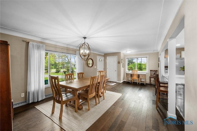 dining room with baseboards, an inviting chandelier, and dark wood-style floors