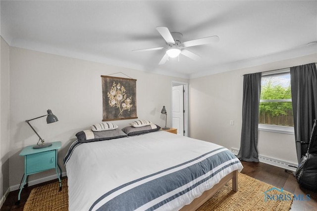 bedroom featuring baseboards, ceiling fan, baseboard heating, and wood finished floors