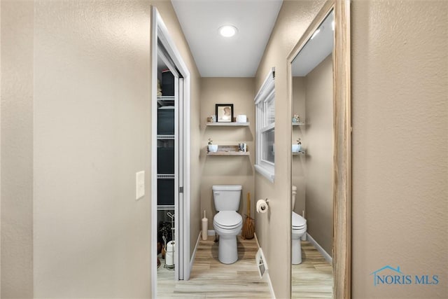 bathroom featuring wood finished floors and toilet