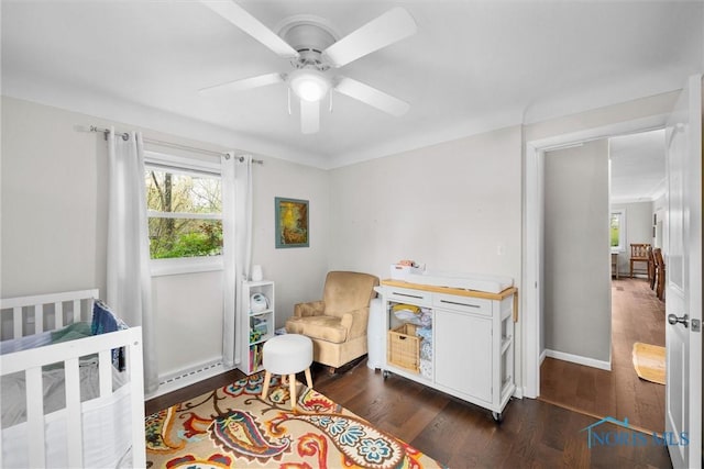 bedroom with ceiling fan, dark wood-style floors, and multiple windows