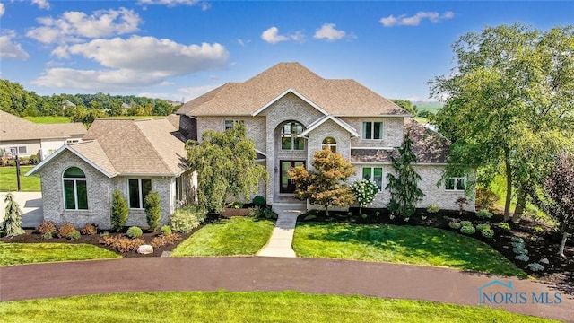 view of front of home with brick siding and a front lawn
