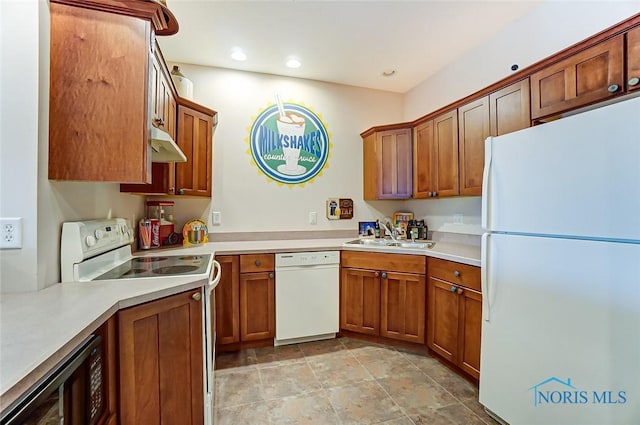kitchen with white appliances, brown cabinetry, and a sink