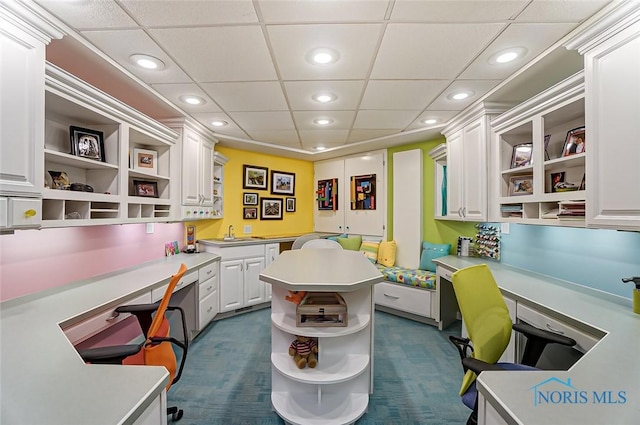 office featuring recessed lighting, a drop ceiling, a sink, and built in study area