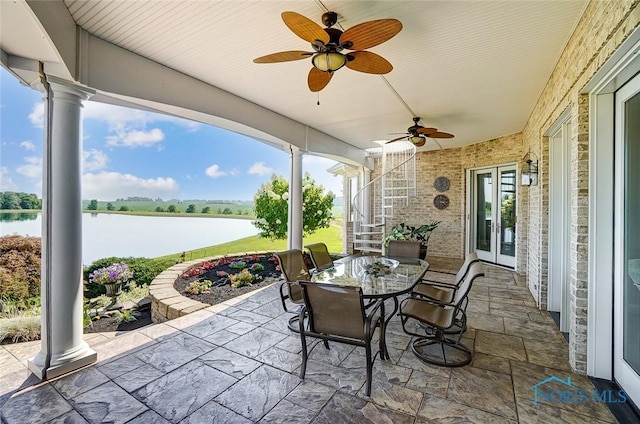 view of patio featuring outdoor dining area, a water view, ceiling fan, and french doors