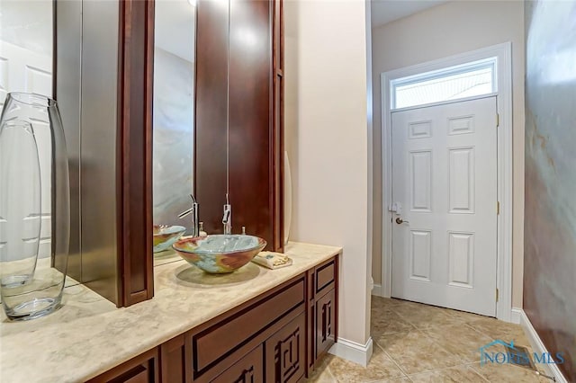 bathroom featuring vanity, tile patterned flooring, and baseboards