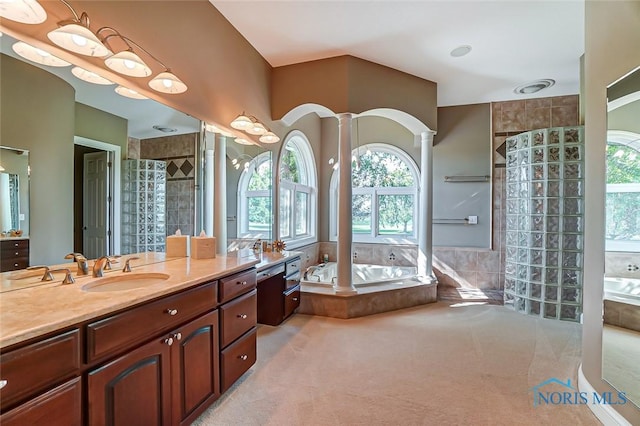 bathroom featuring vanity, decorative columns, walk in shower, and a garden tub