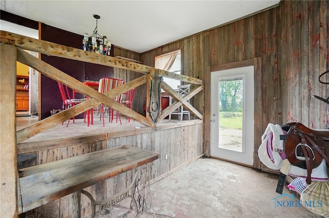 13707 Brint Rd, Berkey, OH 43504 - doorway to outside featuring wooden walls and unfinished concrete flooring