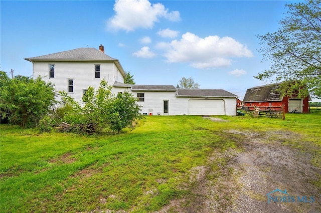13707 Brint Rd, Berkey, OH 43504 - back of house featuring a chimney, driveway, a yard, and an attached garage