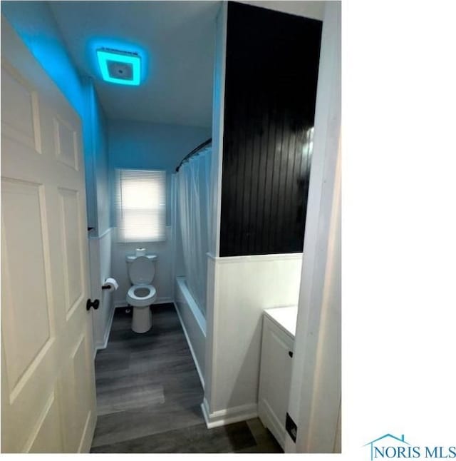 bathroom featuring vanity, shower / tub combo, wood finished floors, and toilet