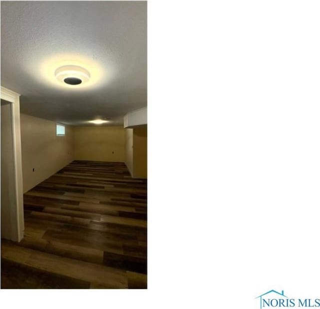 finished basement with a textured ceiling and wood finished floors