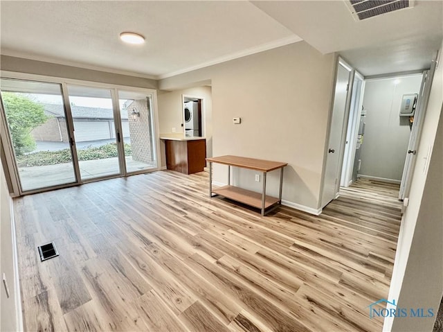 spare room with visible vents, light wood finished floors, and stacked washer / dryer