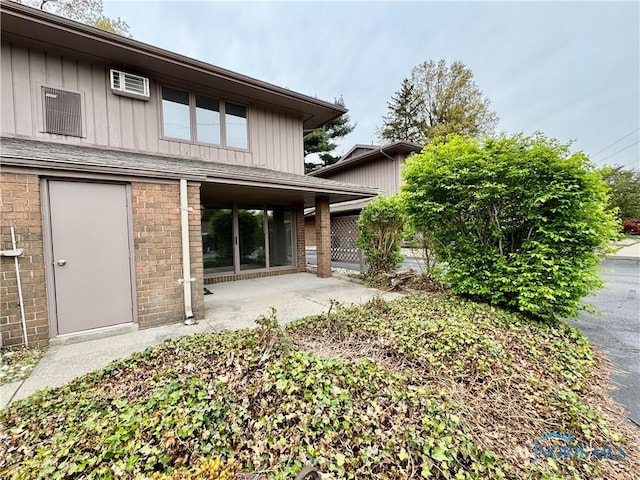back of property featuring board and batten siding and a patio area