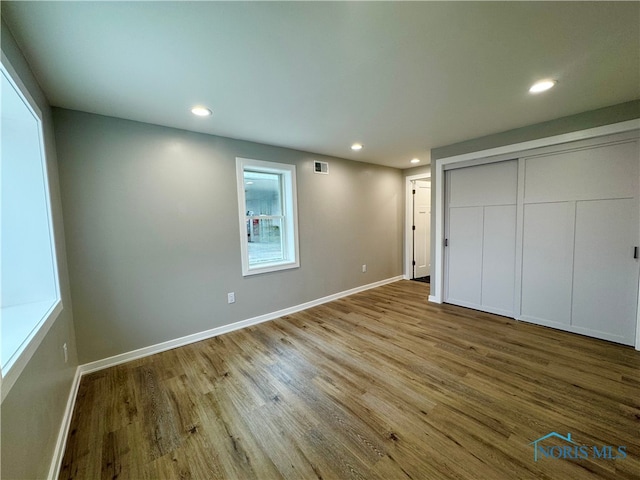 unfurnished bedroom with recessed lighting, baseboards, and wood finished floors