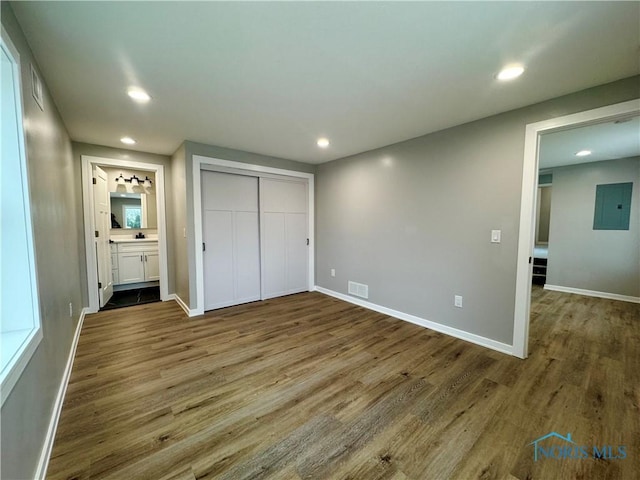 unfurnished bedroom featuring recessed lighting, visible vents, wood finished floors, and electric panel