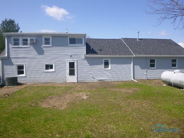back of house with a lawn and central air condition unit