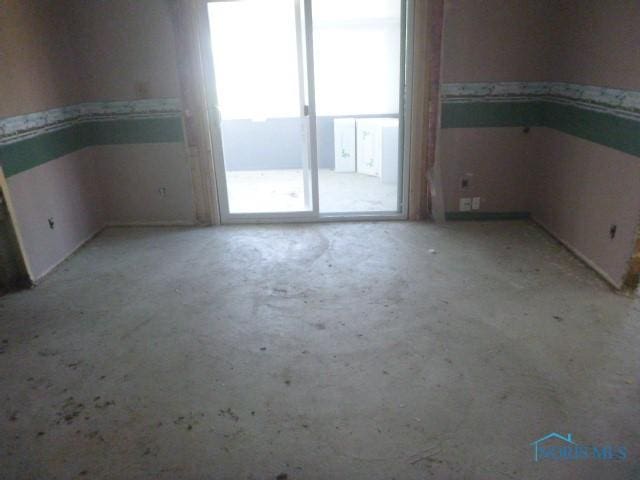 unfurnished room featuring concrete flooring