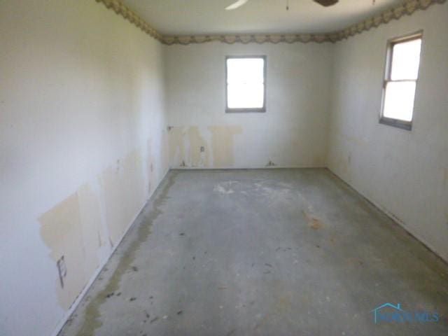 empty room with concrete floors and ceiling fan