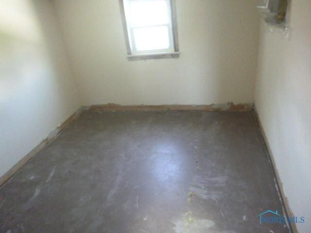 empty room featuring baseboards and concrete flooring