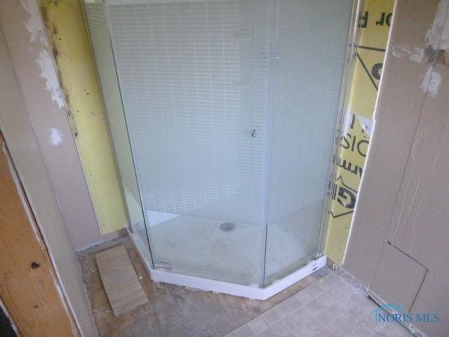 bathroom featuring baseboards and a stall shower