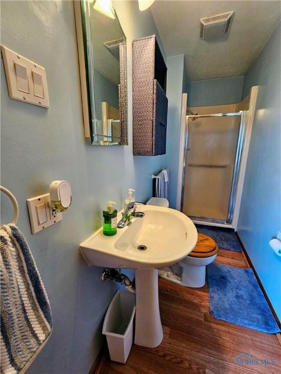 24046 Defiance Pike, Custar, OH 43511 - bathroom with radiator heating unit, a stall shower, wood finished floors, toilet, and a sink