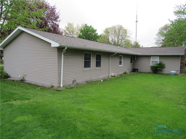rear view of house featuring a yard