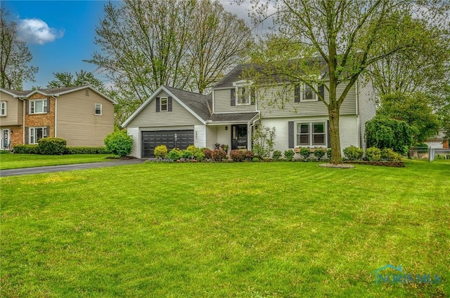 view of front of home featuring an attached garage, a front lawn, and aphalt driveway