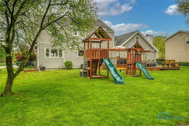 view of playground with a lawn and fence