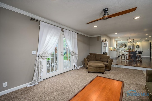 living room featuring baseboards, recessed lighting, carpet, and ceiling fan with notable chandelier