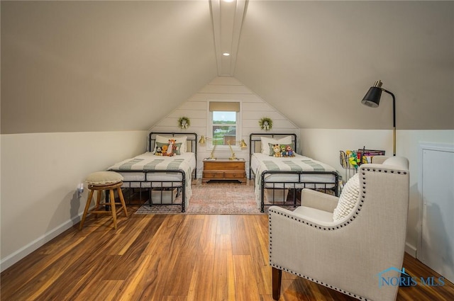 bedroom with baseboards, vaulted ceiling, and wood finished floors