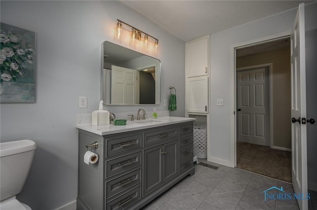 full bath with vanity, baseboards, and toilet