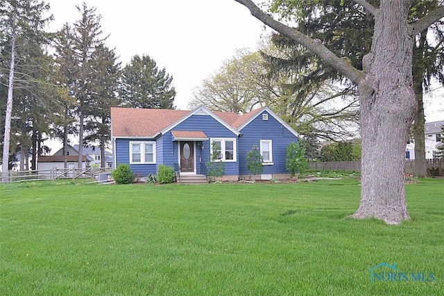 view of front facade with fence and a front lawn