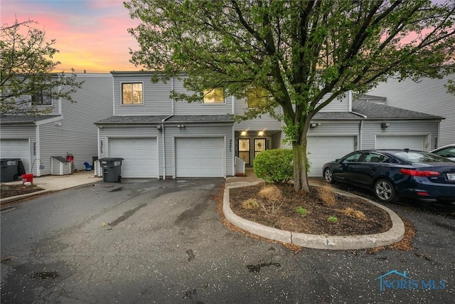 view of front of home with a garage, central air condition unit, and driveway