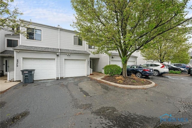 multi unit property featuring a garage and aphalt driveway