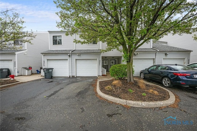 view of front of home featuring cooling unit and aphalt driveway