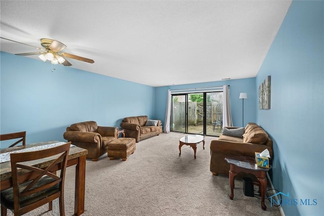 carpeted living area featuring a ceiling fan
