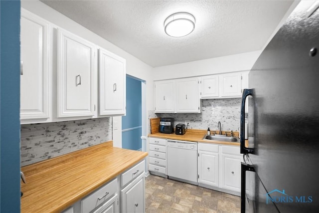 kitchen featuring backsplash, white dishwasher, light countertops, a sink, and freestanding refrigerator