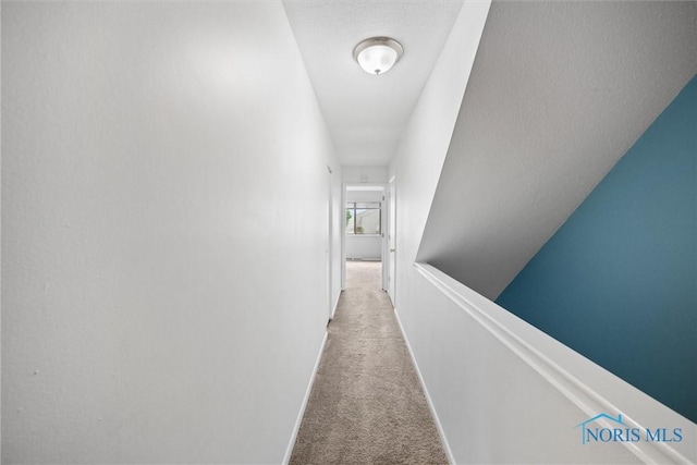 hall with carpet floors and baseboards