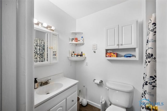bathroom with vanity, baseboards, and toilet