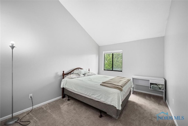 carpeted bedroom featuring baseboards and lofted ceiling