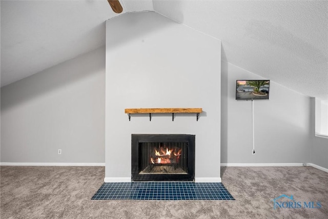 interior details featuring baseboards, a ceiling fan, carpet, and a tile fireplace