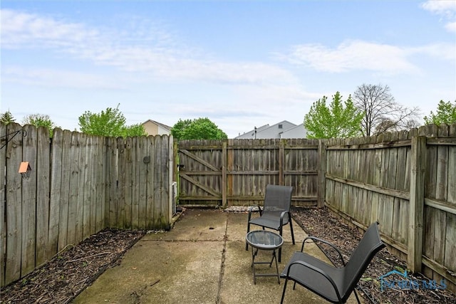 view of patio / terrace featuring a fenced backyard, a gate, and a fire pit