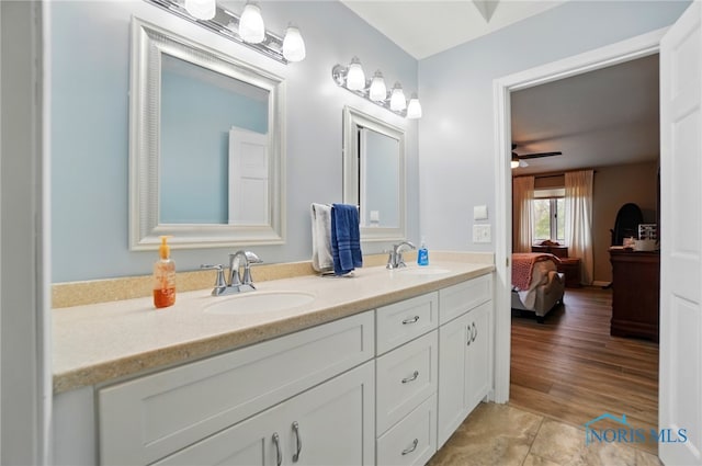 ensuite bathroom with double vanity, ceiling fan, a sink, and ensuite bath