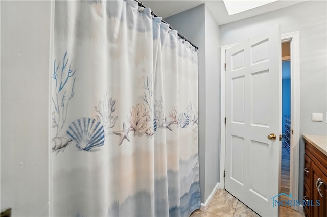 full bath with vanity, baseboards, a skylight, and a shower with curtain