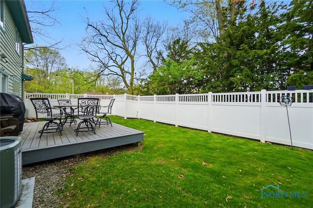 view of yard featuring a fenced backyard, outdoor dining space, cooling unit, and a deck